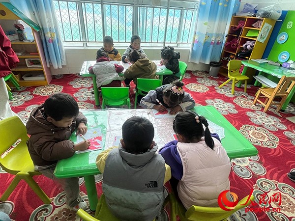 拉多村一所現(xiàn)代化幼兒園小班孩子們正在繪畫(huà)。張敏穎 攝