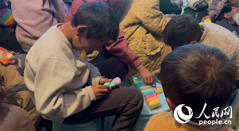 措果鄉(xiāng)塘仁村的孩子們正在用橡皮泥制作自己的情緒“小怪獸”。人民網(wǎng)記者 郝潔攝