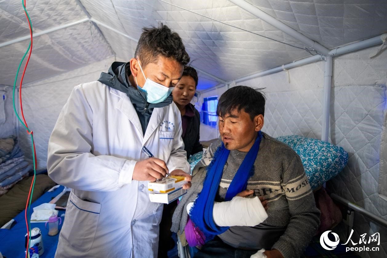 　醫(yī)生正在囑咐洛桑堅參如何用藥。人民網(wǎng)記者 翁奇羽攝