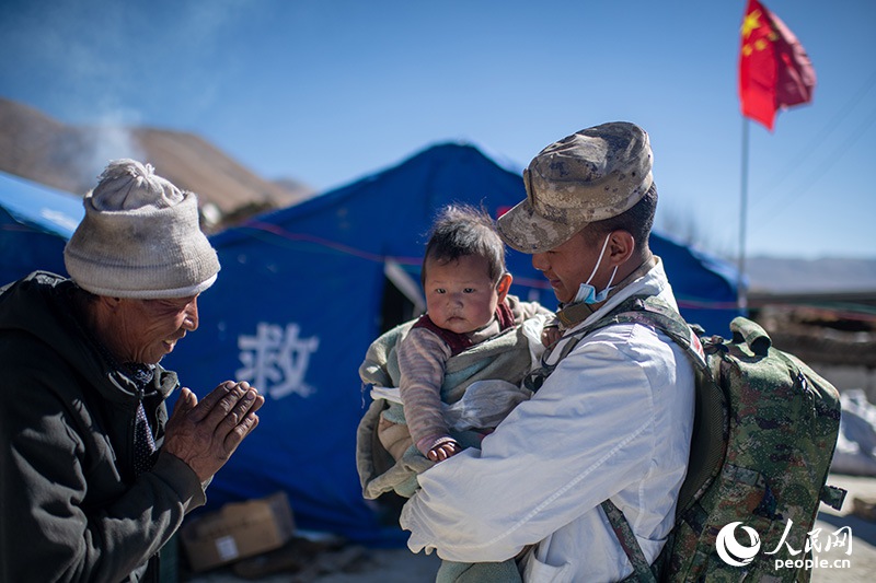 1月9日，在定日縣長所鄉(xiāng)古榮村安置點，受災(zāi)群眾感謝西藏軍區(qū)陸軍某部隊衛(wèi)生員的醫(yī)療救治。人民網(wǎng)記者 翁奇羽攝
