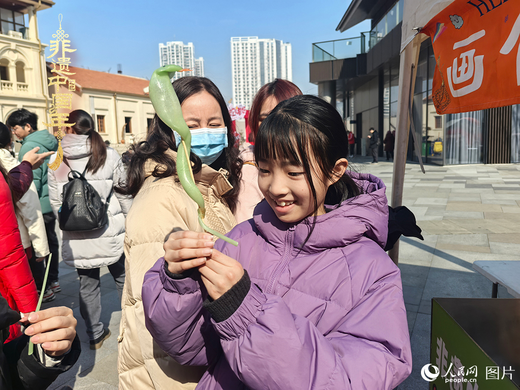 2025年1月29日，湖北武漢的新春廟會(huì)上，小朋友拿著吹制好的糖人，十分開心。人民網(wǎng)記者 張沛攝