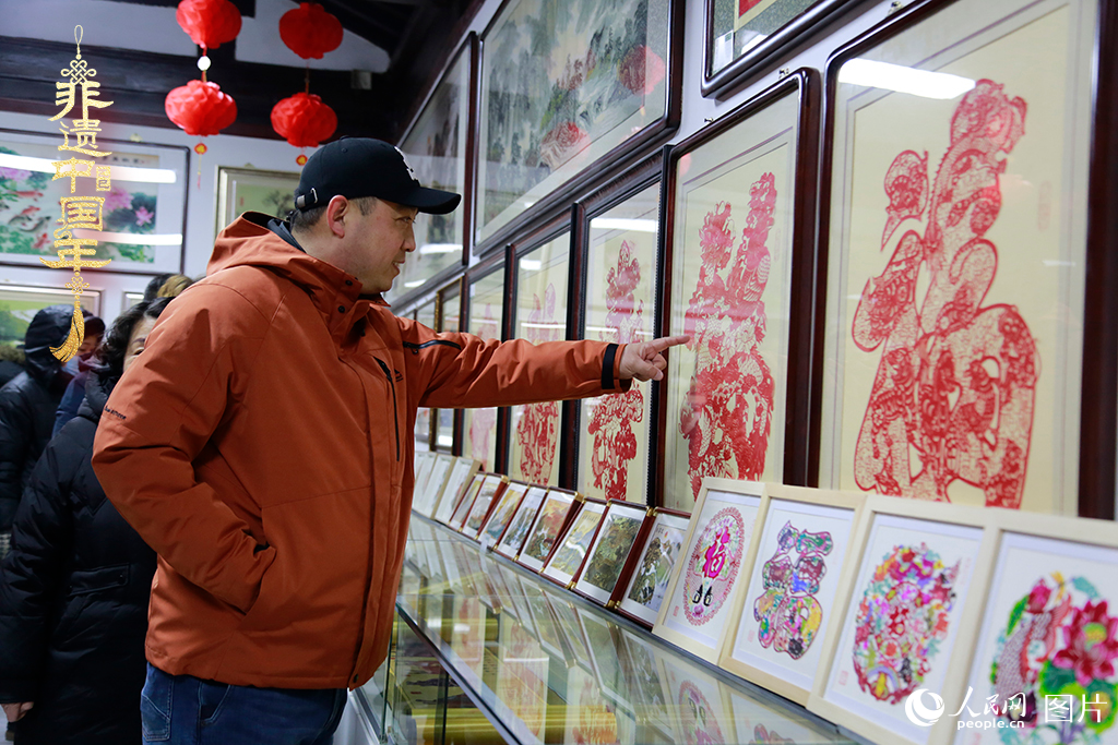 2025年1月23日，游客在天津楊柳青古鎮(zhèn)欣賞傳統(tǒng)剪紙作品，感受指尖上的古老藝術(shù)。人民網(wǎng)記者 崔新耀攝