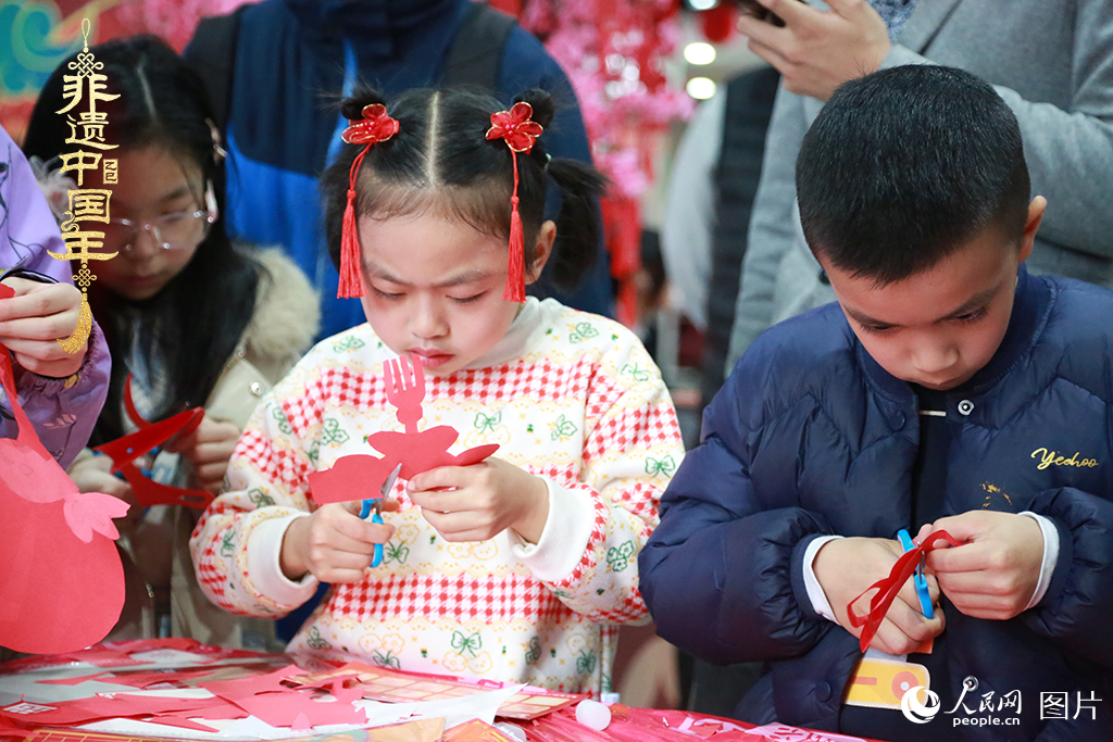 2025年1月23日，上海市青少年活動(dòng)中心迎新春游園會(huì)上，小朋友們正在學(xué)習(xí)剪窗花。人民網(wǎng)記者 龔莎攝