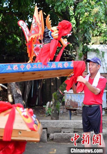 圖為5月29日，長樂江田鎮(zhèn)村民為即將入水的新龍舟系紅布?！埍?攝