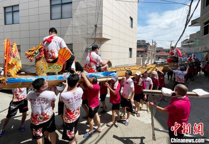 圖為5月29日，長樂江田鎮(zhèn)村民們肩扛著新龍舟舉行入水前游街儀式?！埍?攝