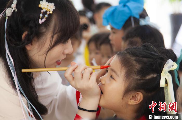 圖為老師在孩子們額頭上點(diǎn)上雄黃，驅(qū)邪辟禍。　董觀生 攝