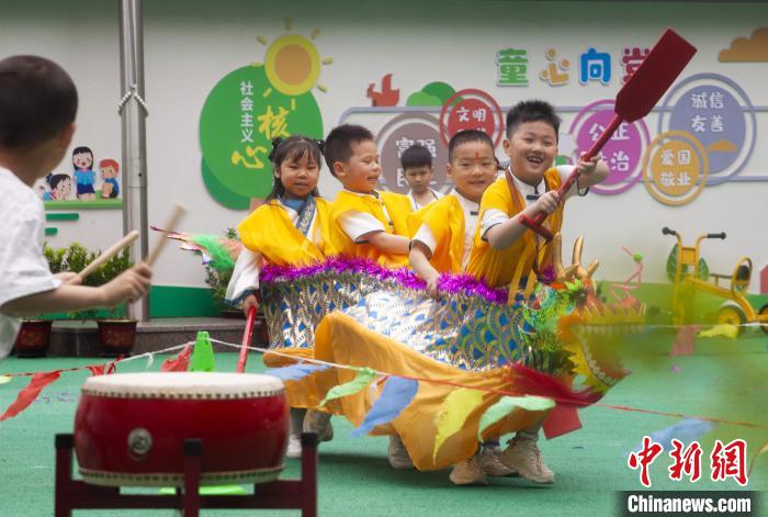 圖為龍舟賽游戲上，小伙伴們打鼓加油。　董觀生 攝